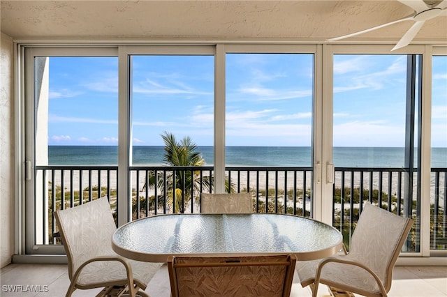 sunroom / solarium with a view of the beach and a water view