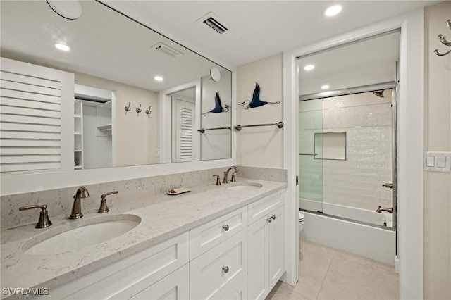 full bathroom featuring vanity, tile patterned floors, shower / bath combination with glass door, and toilet