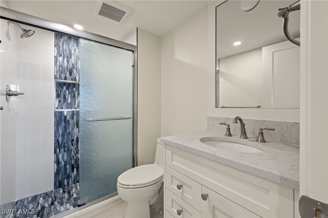 bathroom featuring vanity, toilet, and a shower with door