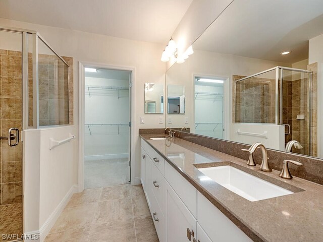 bathroom with dual bowl vanity, a shower with shower door, and tile patterned flooring