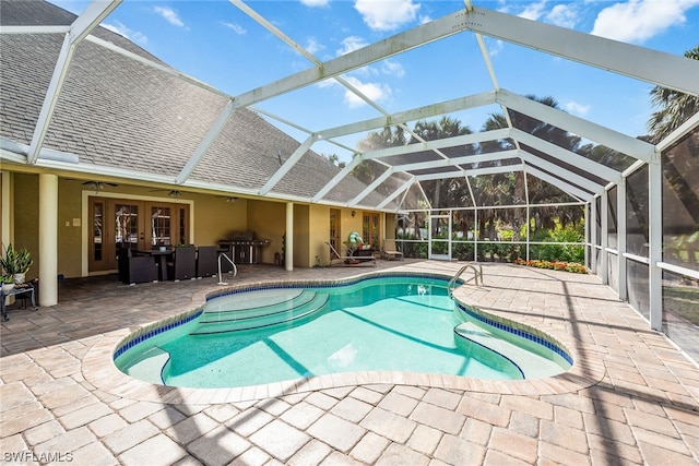 view of swimming pool featuring ceiling fan, a lanai, and a patio area