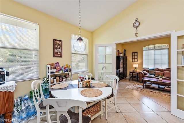 tiled dining area with vaulted ceiling and a healthy amount of sunlight