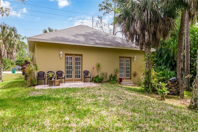 rear view of house with a patio area, a lawn, and french doors