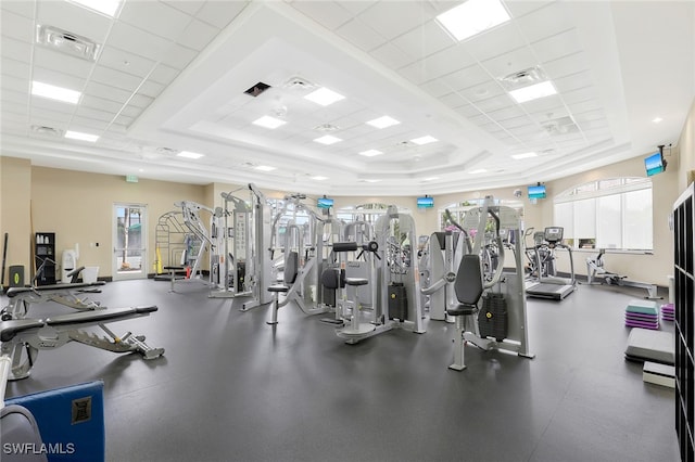 gym featuring a tray ceiling, a paneled ceiling, and ornamental molding