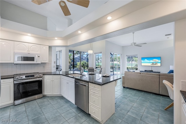 kitchen with sink, white cabinets, light tile patterned floors, and appliances with stainless steel finishes