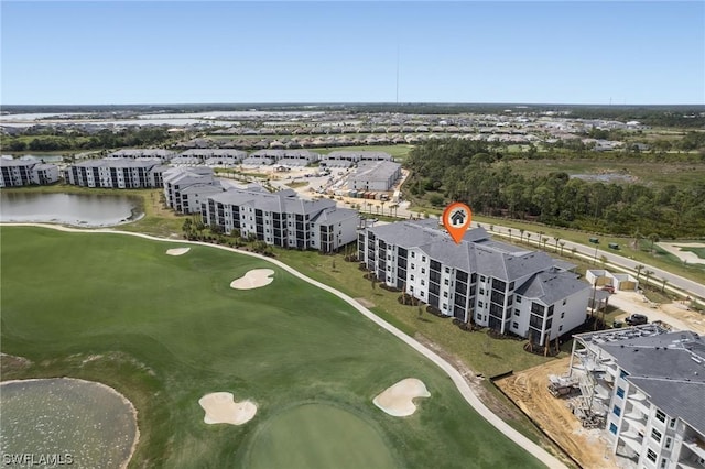 drone / aerial view with golf course view and a water view