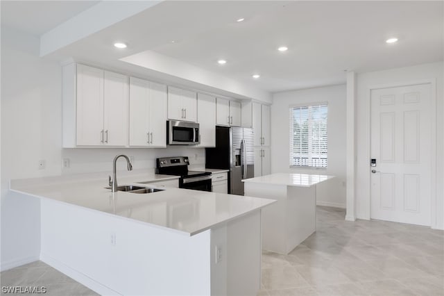 kitchen featuring white cabinets, appliances with stainless steel finishes, light tile floors, and sink