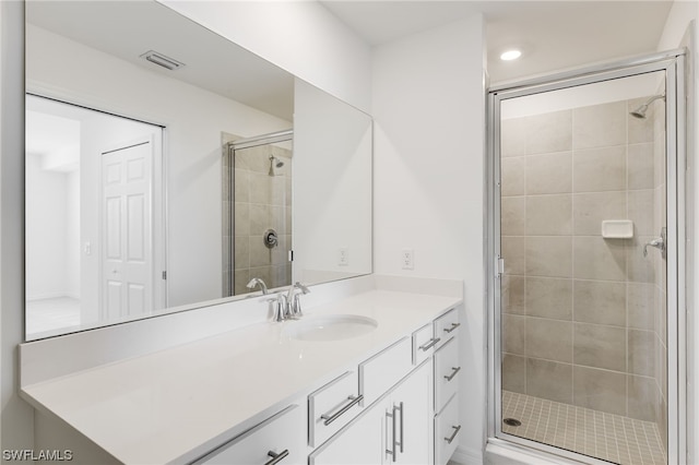 bathroom with vanity and a shower with door