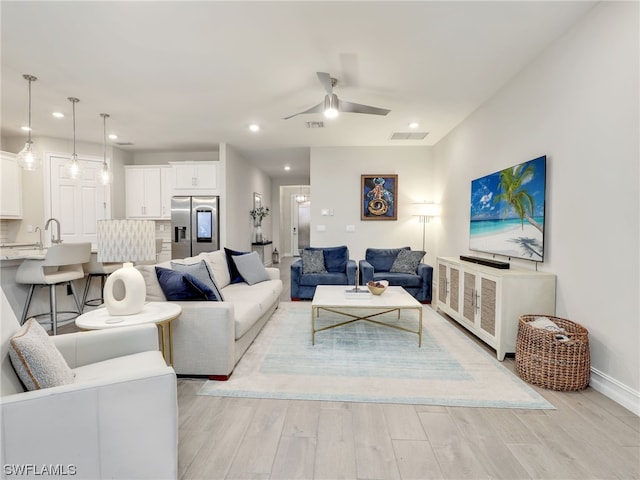 living room featuring ceiling fan and light wood-type flooring