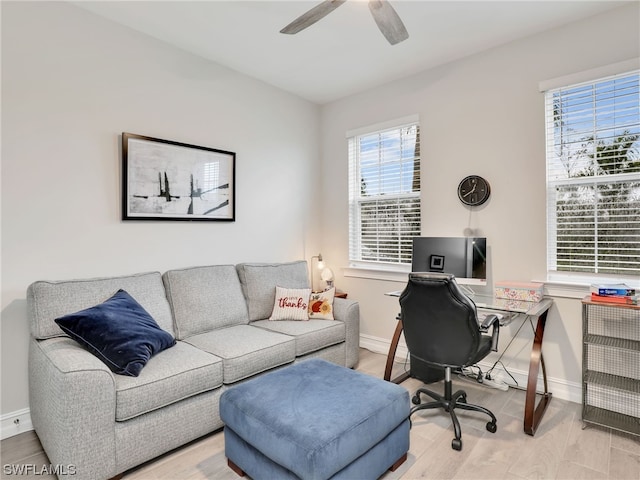 home office featuring ceiling fan, a healthy amount of sunlight, and light wood-type flooring