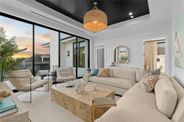 living room with a healthy amount of sunlight and a raised ceiling