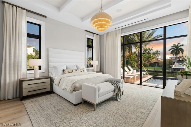 bedroom featuring access to exterior, an inviting chandelier, and light wood-type flooring