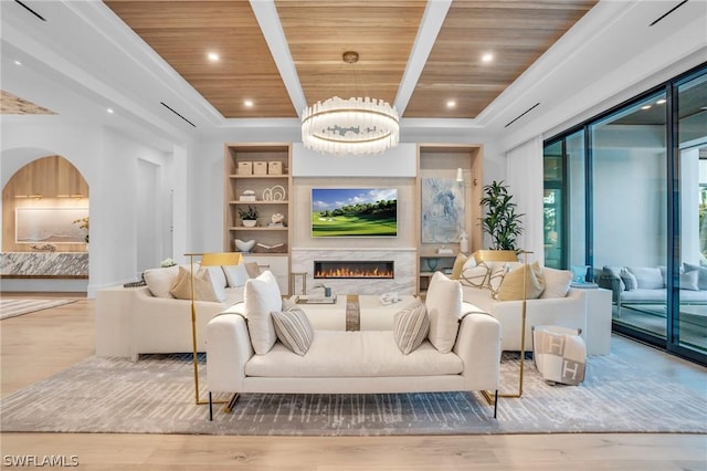 living room featuring a high end fireplace, built in shelves, wooden ceiling, a chandelier, and light hardwood / wood-style floors