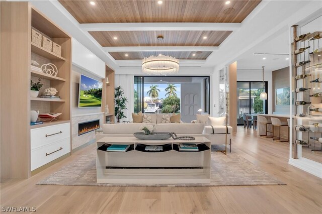 living room featuring a notable chandelier, beam ceiling, light wood-type flooring, and wooden ceiling