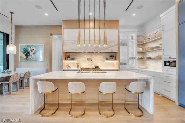 interior space featuring white cabinets, light wood-type flooring, and sink