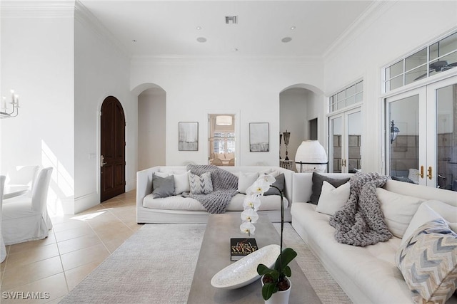 tiled living room featuring ornamental molding and french doors