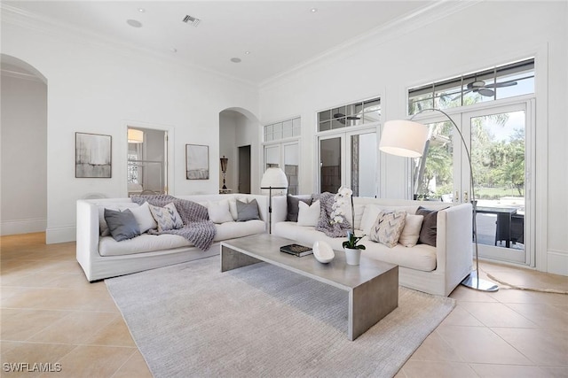 tiled living room featuring crown molding, a high ceiling, and french doors