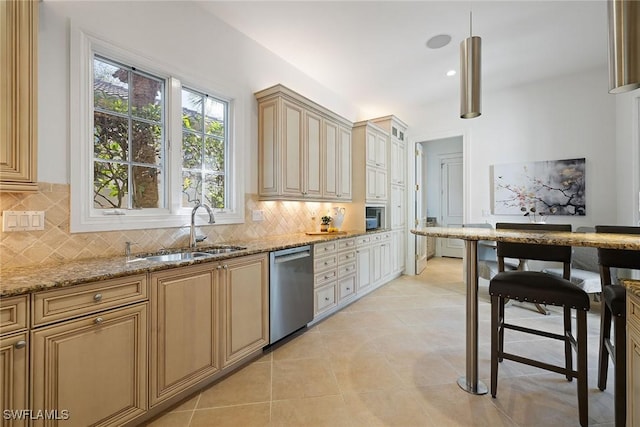 kitchen featuring stainless steel appliances, sink, backsplash, and light stone counters