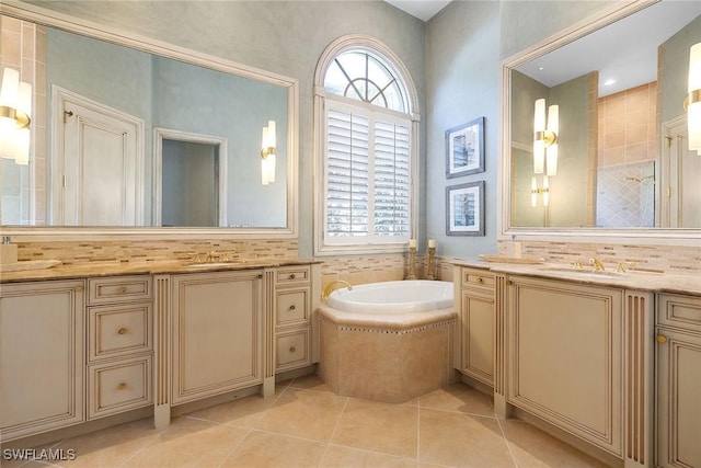 bathroom featuring tile patterned floors, vanity, and a relaxing tiled tub