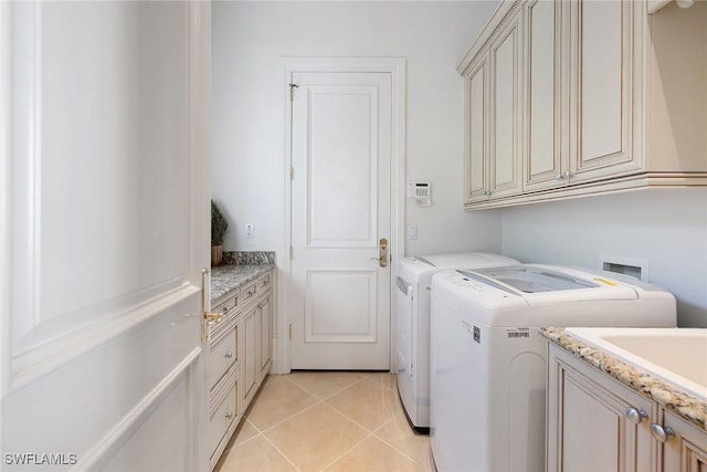 laundry area featuring cabinets, independent washer and dryer, sink, and light tile patterned floors