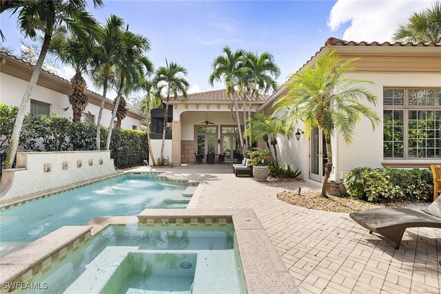 view of swimming pool with an in ground hot tub, ceiling fan, and a patio area