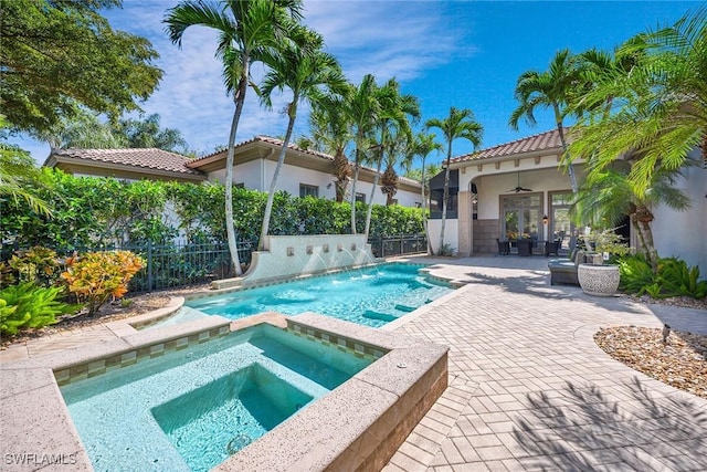 view of swimming pool with an in ground hot tub, ceiling fan, a patio, and pool water feature