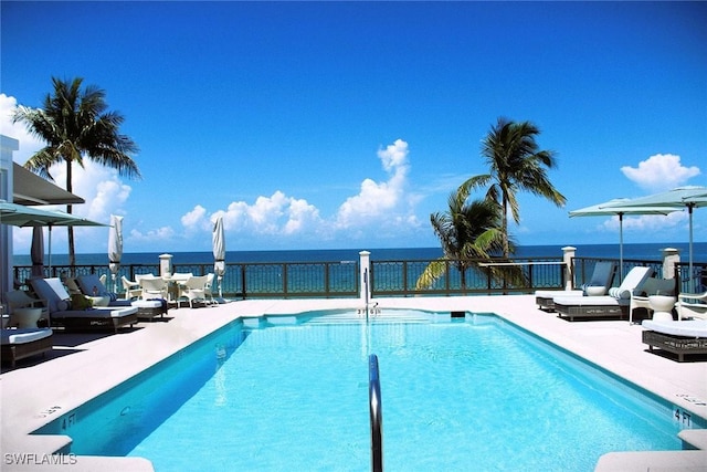 view of pool featuring a patio area and a water view