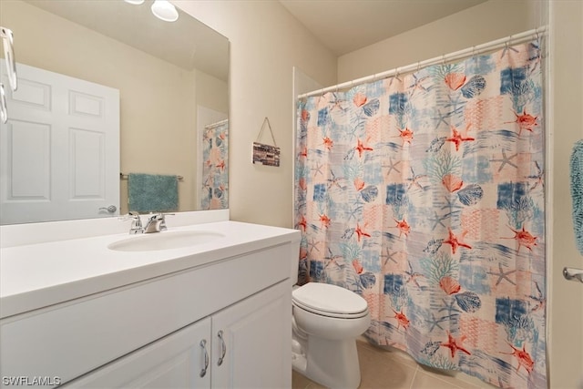 bathroom with toilet, tile floors, and vanity with extensive cabinet space