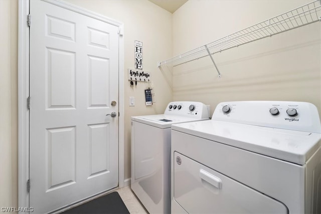 clothes washing area featuring independent washer and dryer and light tile flooring