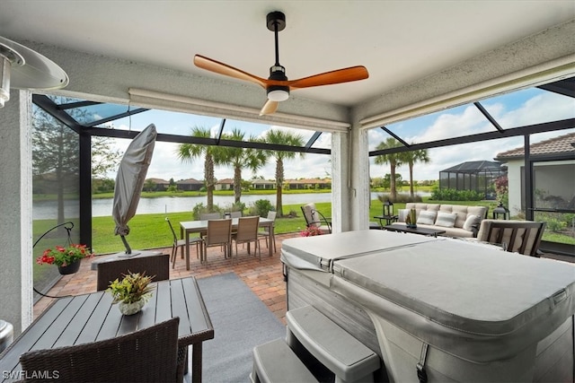 sunroom with a water view and ceiling fan