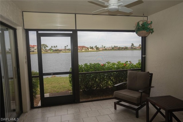 sunroom / solarium with a water view, plenty of natural light, and ceiling fan