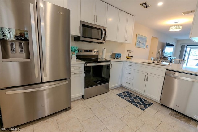 kitchen featuring light tile patterned floors, stainless steel appliances, sink, and white cabinets