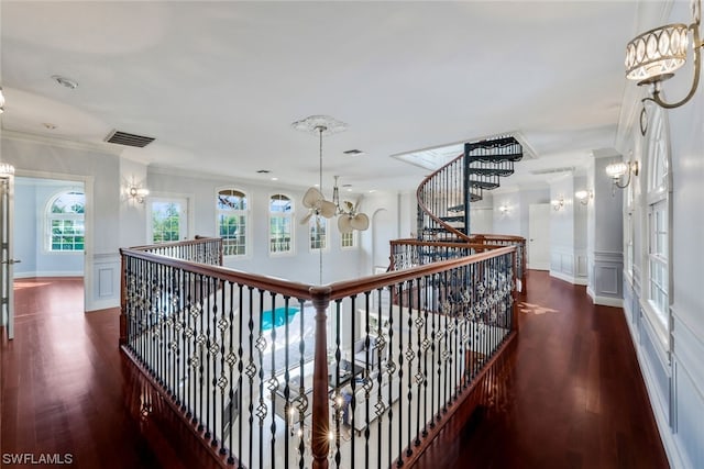 hall featuring a chandelier, crown molding, and dark wood-type flooring