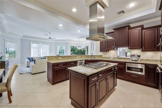 kitchen with appliances with stainless steel finishes, a center island, island range hood, crown molding, and light stone countertops