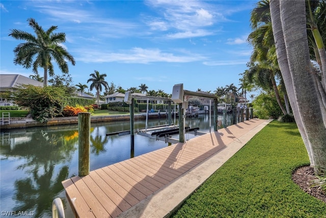 view of dock with a yard and a water view