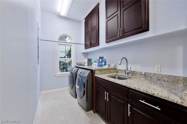 washroom featuring light tile floors, cabinets, separate washer and dryer, and sink