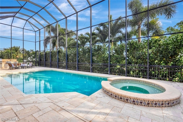 view of swimming pool featuring a lanai, an in ground hot tub, and a patio area