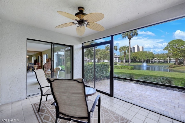 unfurnished sunroom with a water view and ceiling fan