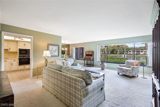 living room with light carpet and ceiling fan with notable chandelier