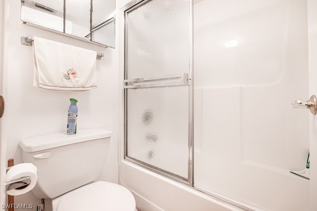 bathroom featuring bath / shower combo with glass door and toilet