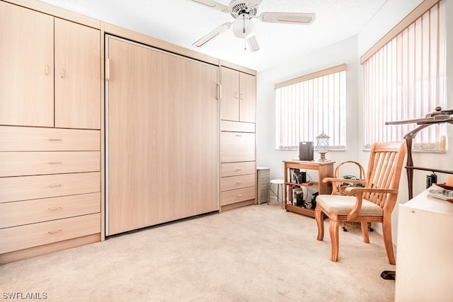 living area with light carpet and ceiling fan