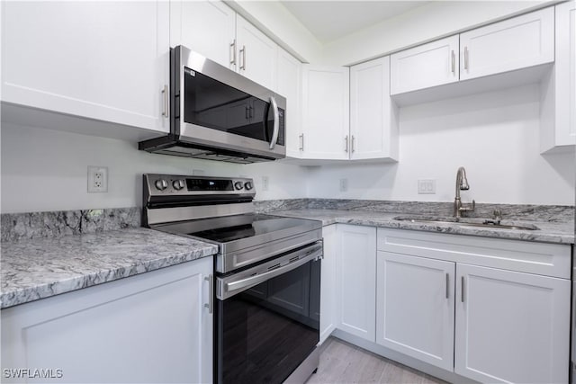 kitchen with white cabinets, sink, and appliances with stainless steel finishes