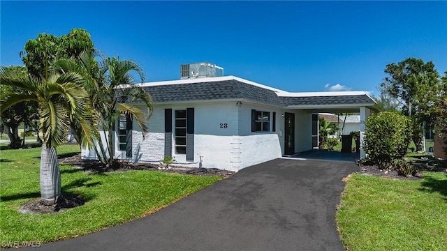 view of front of house featuring a carport and a front lawn