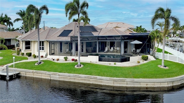 back of property featuring a pool with hot tub, a yard, and a water view