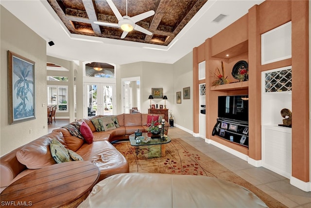 living room with french doors, ceiling fan, coffered ceiling, light tile flooring, and a tray ceiling