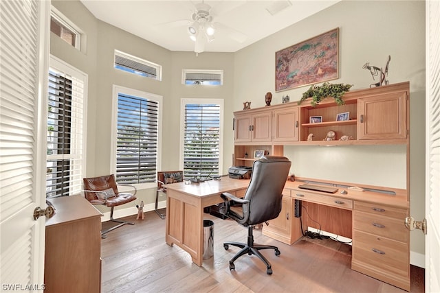 office area featuring hardwood / wood-style floors, ceiling fan, and built in desk