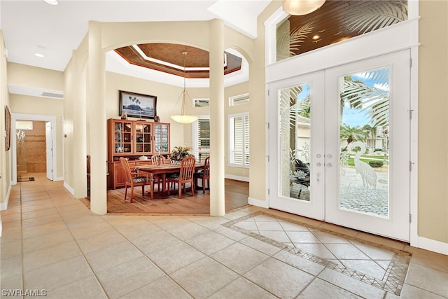 entryway with french doors, light tile flooring, and ornamental molding