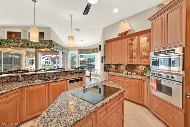 kitchen featuring decorative light fixtures, appliances with stainless steel finishes, dark stone countertops, light tile floors, and tasteful backsplash