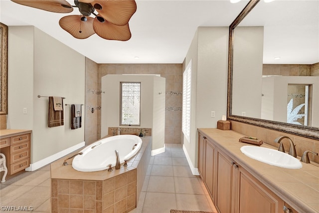 bathroom featuring vanity, tile flooring, ceiling fan, and tiled tub