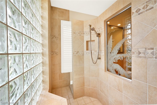 bathroom with plenty of natural light, tile walls, and tiled shower